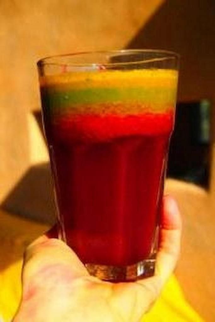 close-up of woman holding a glass with superfood juice from Korogonas Ark
